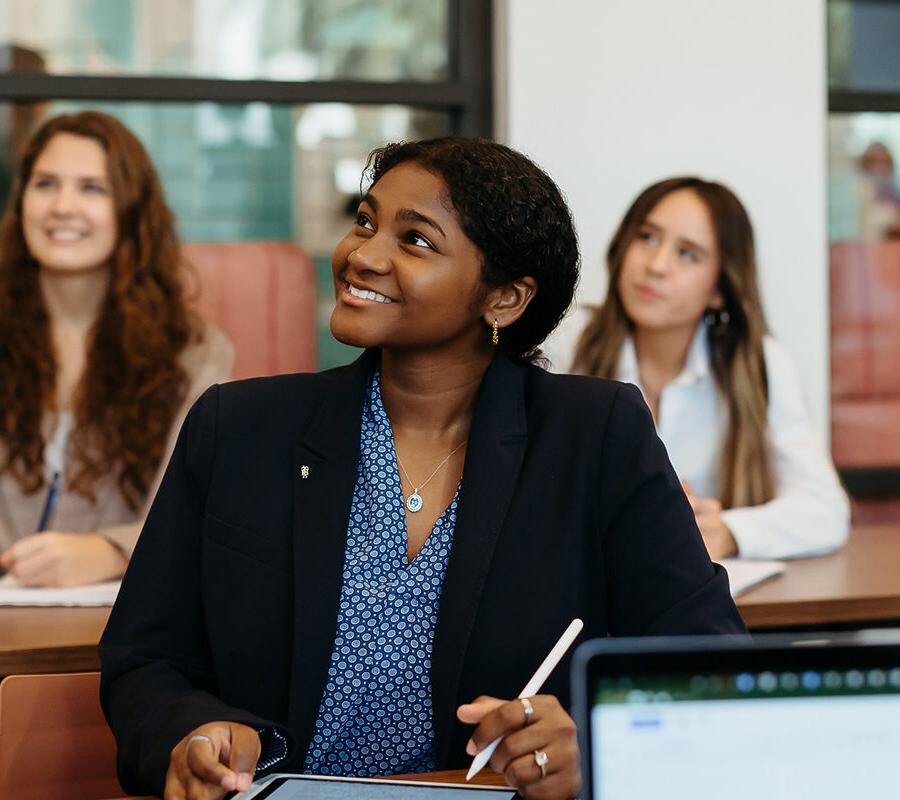 female students smiling 和 taking notes at 十大赌博网站